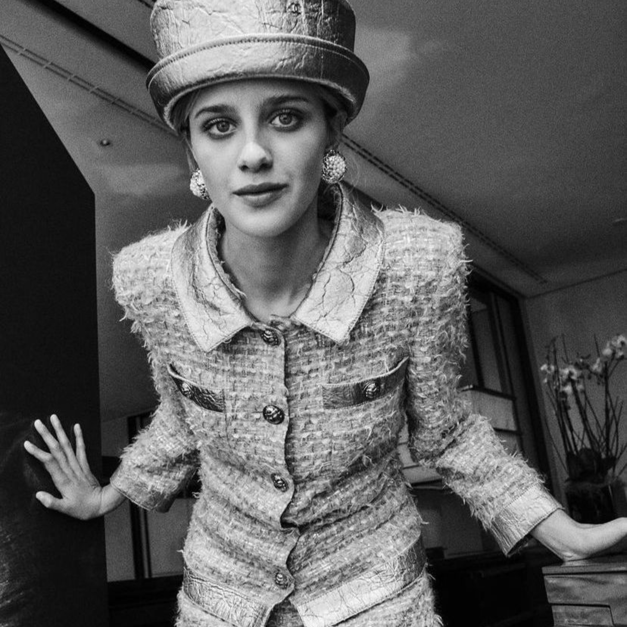 Black and white photo of a person wearing a vintage outfit with a hat.