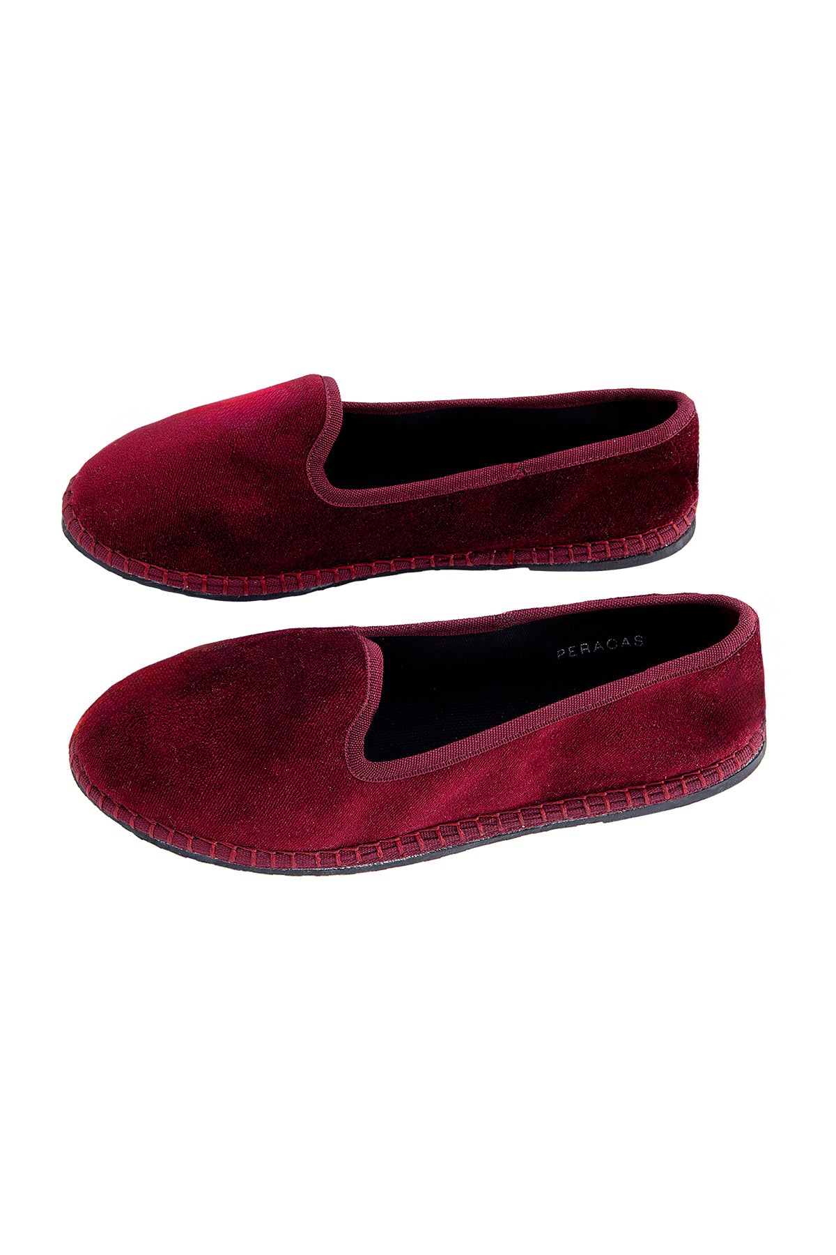 Pair of maroon velvet slippers on a white background