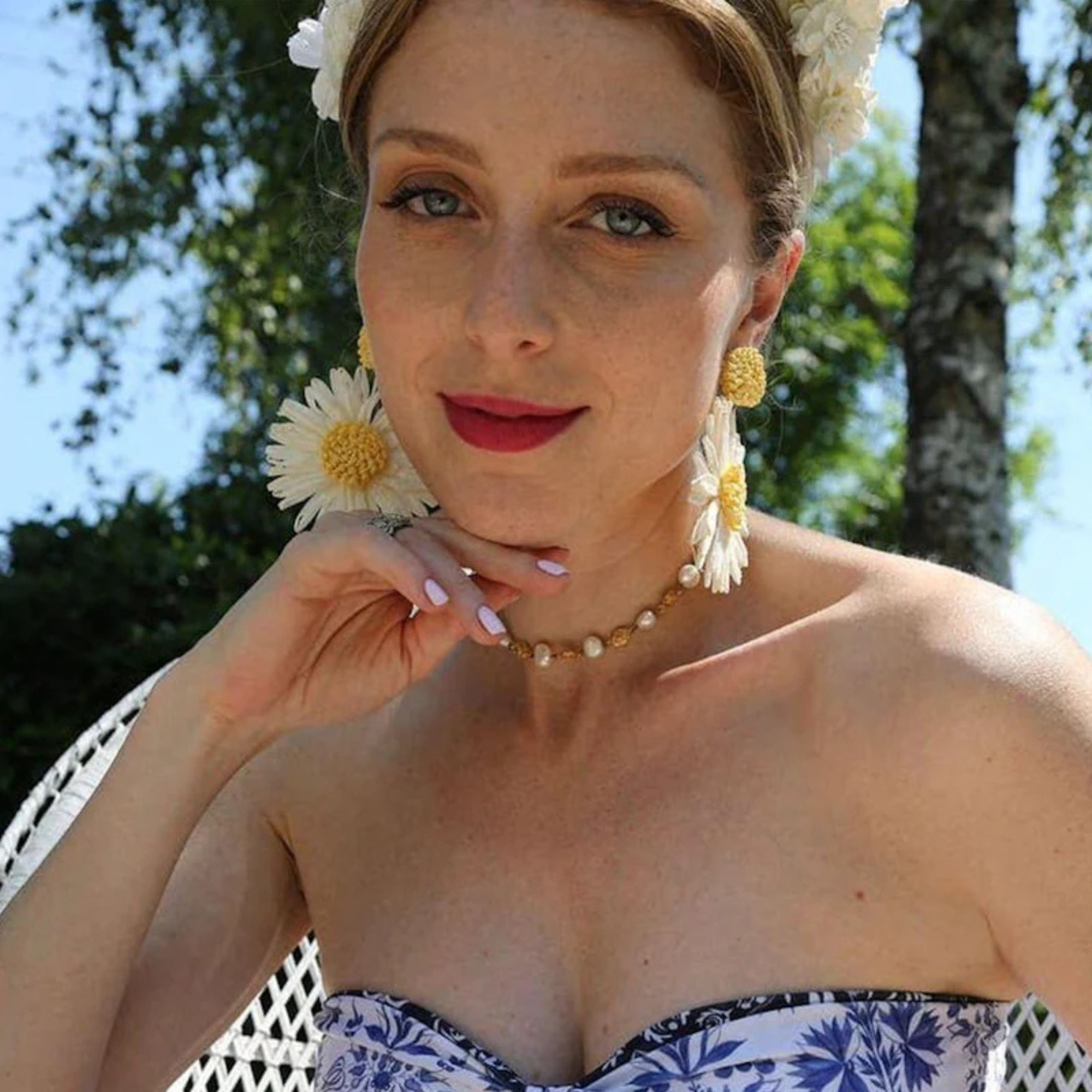 Woman wearing floral earrings and a strapless top outdoors